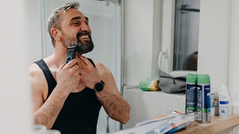 man kijkt in spiegel terwijl hij panasonic multishape gebruikt als scheerapparaat